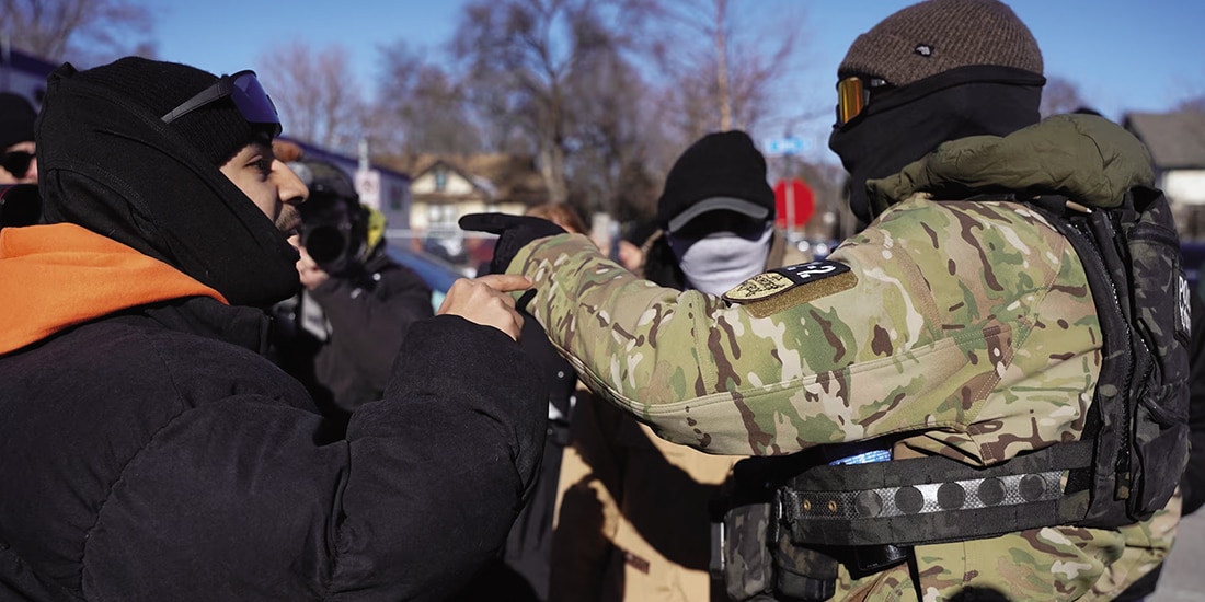 Agente habla con un observador comunitario en Minneapolis, el 14 de enero