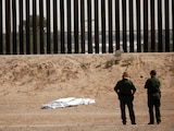 U.S. Border Patrol agents observe the body of a person covered in a white sheet near the border wall in El Paso, Texas, U.S., as seen from Ciudad Juarez, Mexico June 11, 2021. REUTERS/Jose Luis Gonzalez TPX IMAGES OF THE DAY