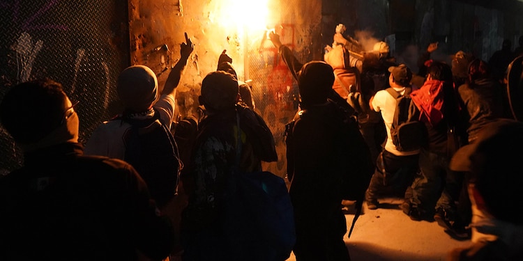 Miembros del Bloque Negro prenden fuego a las vallas.