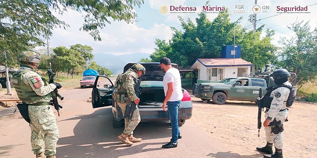 EJÉRCITO y GN al custodiar, ayer, uno de los vehículos asegurados en Michoacán.