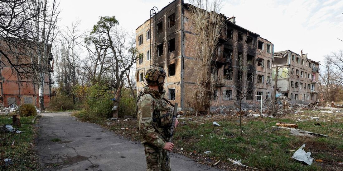 Un militar ucraniano junto a edificios residenciales muy dañados por los permanentes ataques militares rusos en la ciudad de Avdiivka.