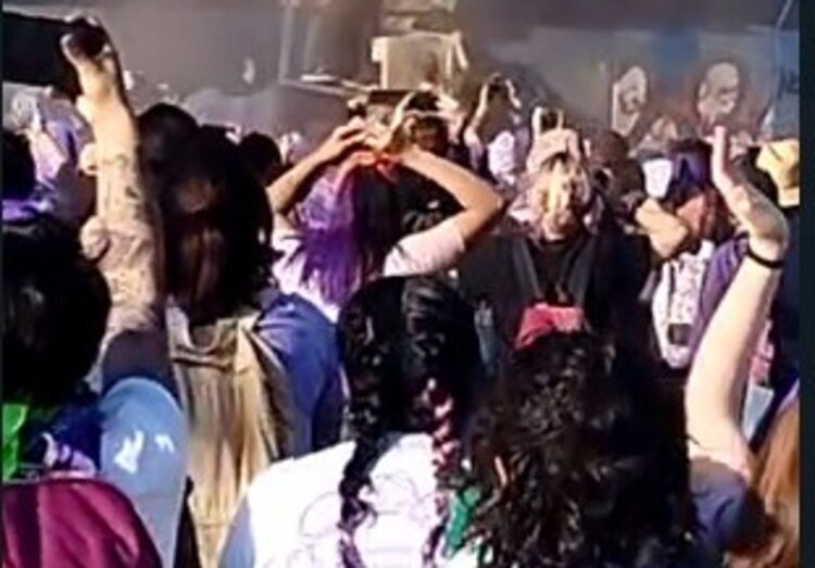 #8M2023. Una de las manifestantes intenta saltarse las vallas que protegen la capital y un policía la avienta empujándola del rostro.