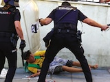 UN POLICÍA golpea a un migrante, ayer, en Ceuta.