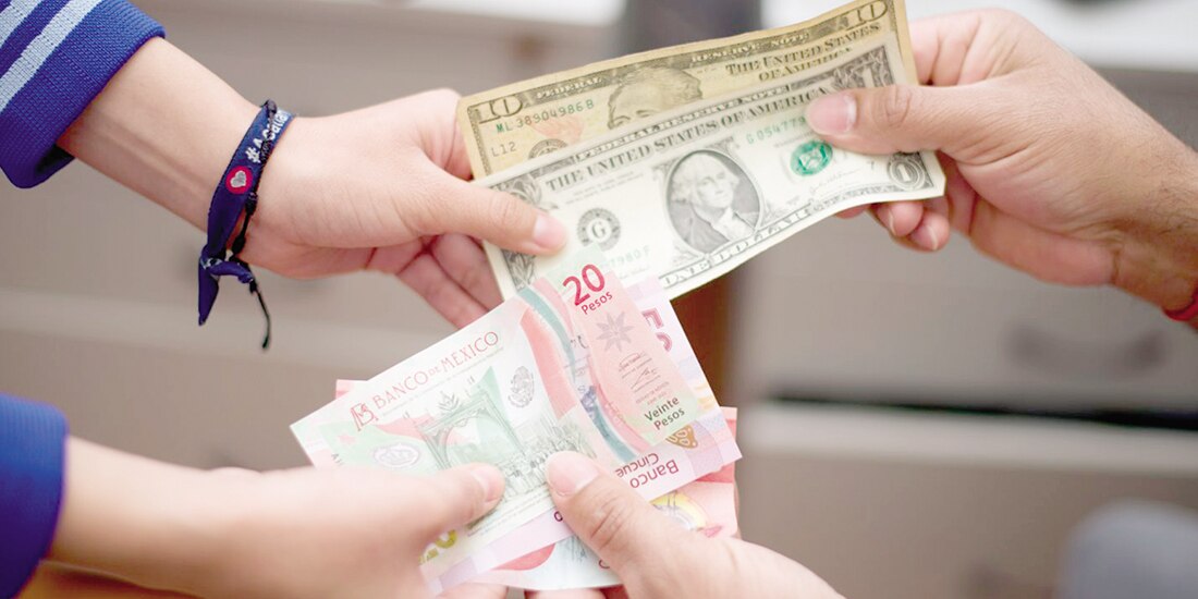 Intercambio de pesos a dólares al interior de una casa de cambio, en imagen de archivo.