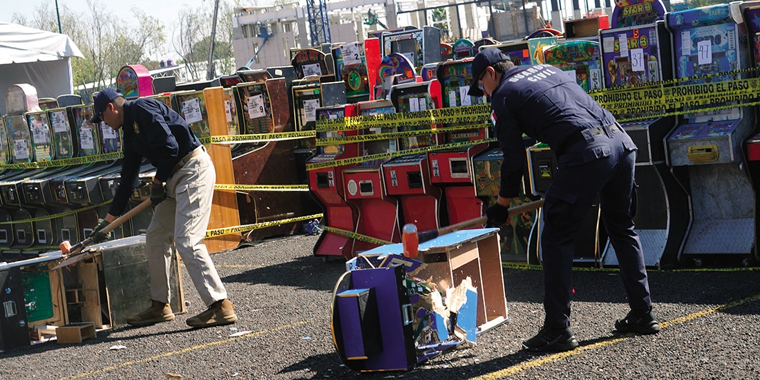 Elementos de seguridad de Michoacán destruyen máquinas tragamonedas, ayer.