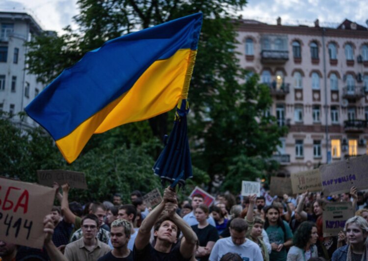 Un hombre ondea una bandera durante una protesta en Ucrania.