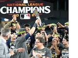 Christian Yelich celebra con sus compañeros y el trofeo, ayer.