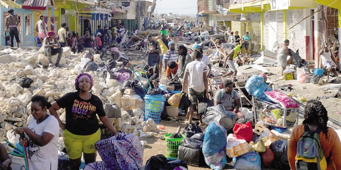 Residentes se reúnen entre los escombros en una calle de Black River, Jamaica, el pasado jueves.