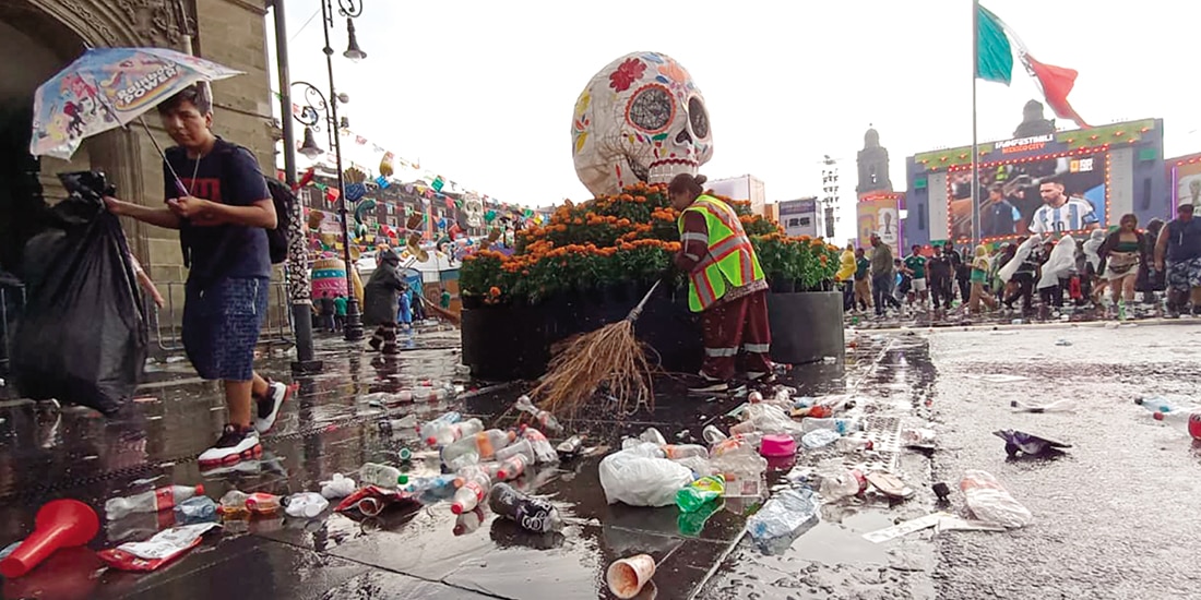 Trabajadores de limpia barren la basura tras el partido y la lluvia en el Zócalo, ayer.