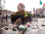 Trabajadores de limpia barren la basura tras el partido y la lluvia en el Zócalo, ayer.