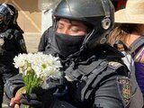 Una mujer entrega flores a una policía de la Secretaría de Seguridad Ciudadana, en el marco de las movilizaciones del 8M.