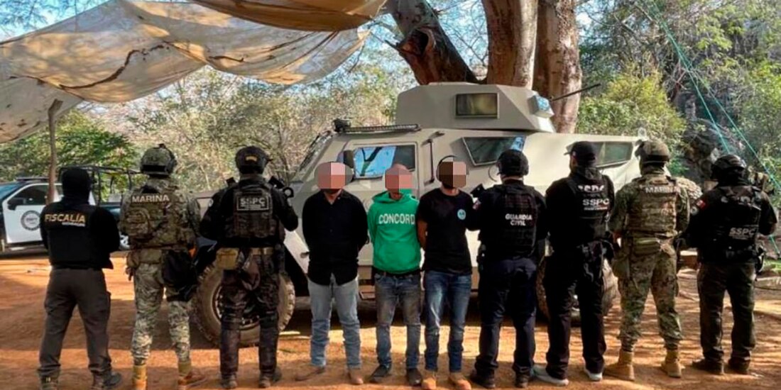 Elementos de seguridad con tres de los ocho detenidos, ayer, en el operativo.