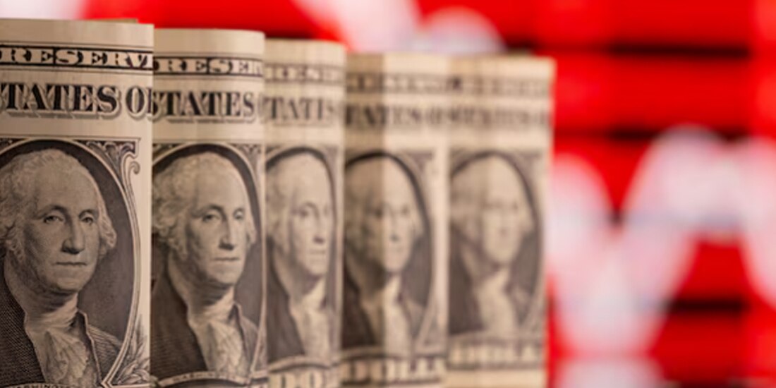 En esta ilustración tomada el 8 de febrero de 2021 se ven billetes de un dólar estadounidense frente a un gráfico bursátil