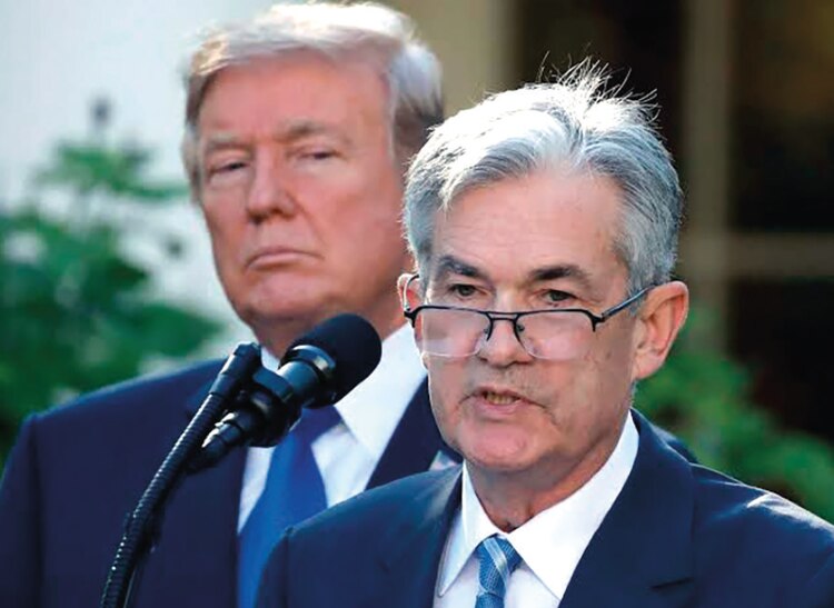 Jerome Powell, presidente de la Reserva Federal, y Donald Trump, al fondo.