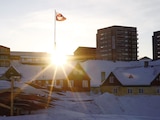 El sol sale detrás de la bandera de Groenlandia en el antiguo puerto de Nuuk, Groenlandia, el 5 de febrero de 2025.