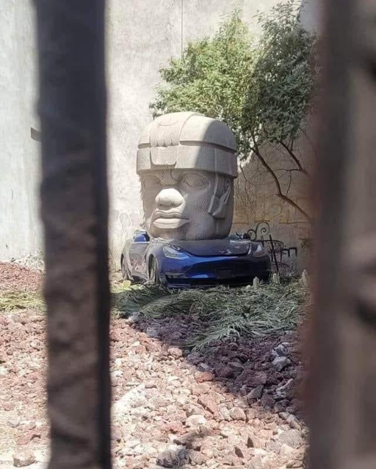Esta es la cabeza Olmeca aplastando a un Tesla, cuyo autor es Chivis Mármol.