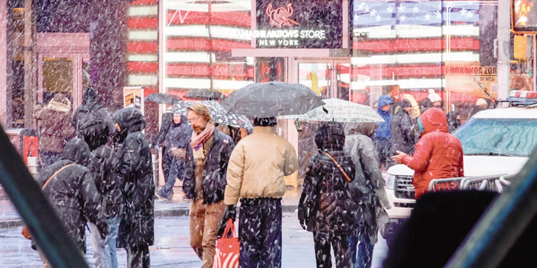 La gente camina por Times Square mientras cae nieve en Nueva York, ayer.