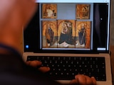 Fotografía ilustrativa de una persona mirando el sitio web del museo de Messina, donde se aprecia la imagen de una obra del pintor renacentista Antonello de Messina, con los paneles robados.