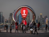 Gente reunida alrededor del reloj de la cuenta regresiva oficial que muestra el tiempo restante para el inicio del Mundial Qatar 2022.