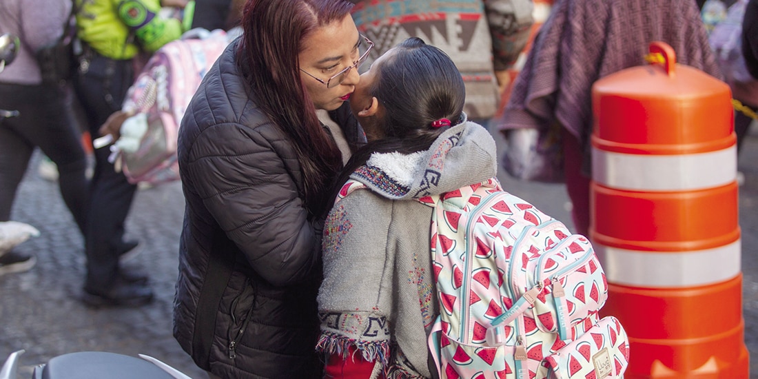 Una madre al despedirse ayer de su hija, previo a que ingrese a la escuela.