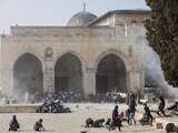 Palestinos chocan con las fuerzas de seguridad israelíes frente a la mezquita de Al Aqsa, en Jerusalén, ayer.