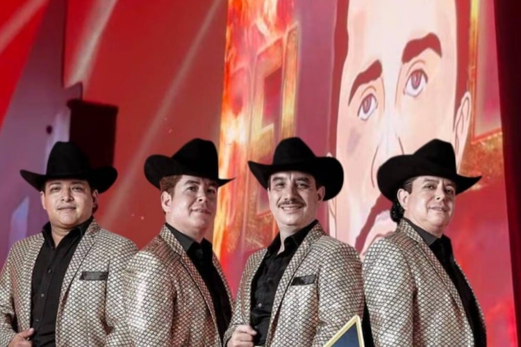 Los integrantes de Los Alegres del Barranco posan con una imagen del capo del narco El Mencho.