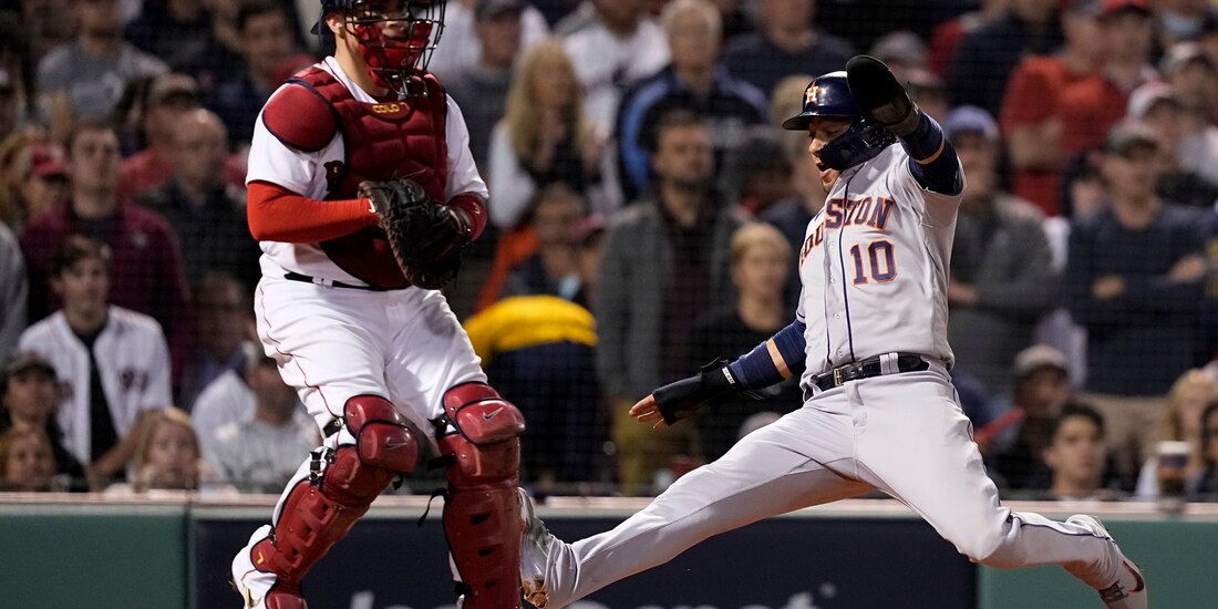 Yuli Gurriel, de los Astros, anota sobre el receptor de los Red Sox, Christian Vázquez, en la sexta entrada.