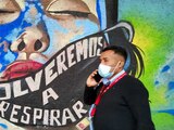 COVID-19: Una persona camina frente a un mural con el mensaje "Volveremos a respirar"