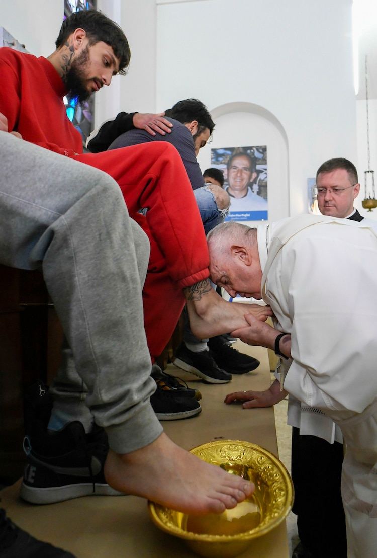 El papa Francisco besa el pie de uno de los 12 internos durante un ritual en Casal del Marmo, ayer.