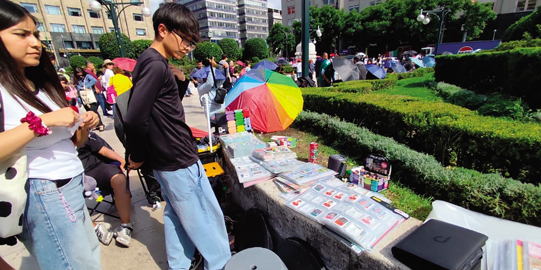 Jóvenes revisan las estampas de un vendedor, ayer, en Bellas Artes.