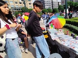 Jóvenes revisan las estampas de un vendedor, ayer, en Bellas Artes.
