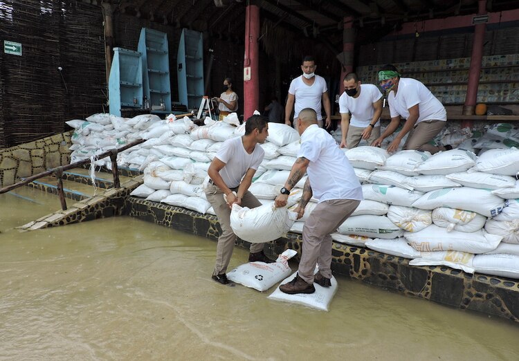 Empleados de un restaurante colocan sacos de arena en la entrada del negocio antes de la llegada del huracán Olaf, en Cabo San Lucas, Baja California Sur, ayer.