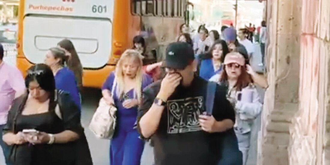 Asistentes a la FICM se cubren la nariz tras el humadero en la zona, ayer.