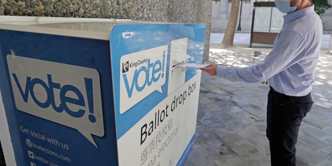 Una persona deposita una boleta, durante las primarias en Washington, ayer.