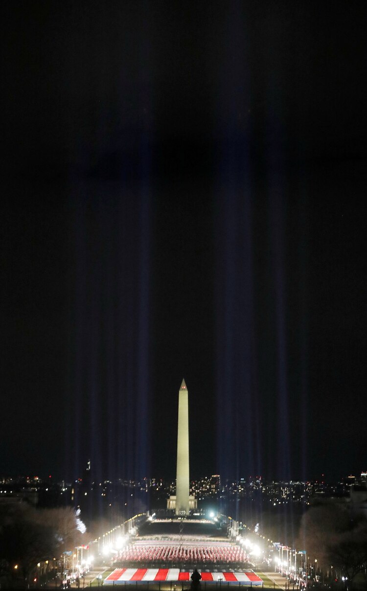Luces iluminan el monumento a Washington desde el “campo de banderas” en el National Mall.