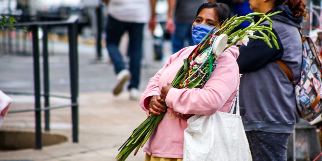 Una mujer carga la imagen de San Judas Tadeo afuera de la iglesia de San Hipólito.