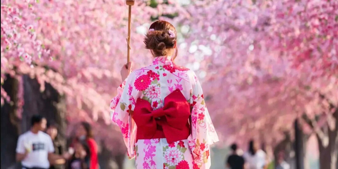 Una mujer caminando entre las flores.