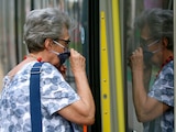 People wear face masks to protect against the coronavirus as they ride with public transport in Vienna, Austria, Wednesday, July 15, 2020. (AP Photo/Ronald Zak)