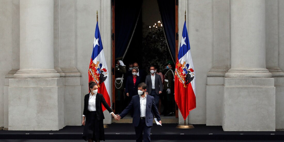 El mandatario chileno de la mano de su esposa, Irina Karamanos, minutos antes de anunciar a su nuevo gabinete (que avanza detrás de él).