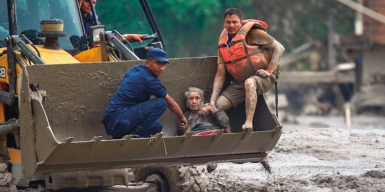 Rescatistas utilizan una excavadora para trasladar a una víctima en Nuwakot, ayer.
