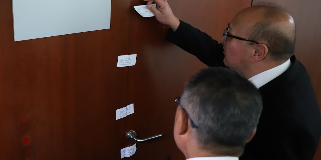 Personal de resguardo parlamentario colocan sellos de clausura al salón de belleza en el Senado.