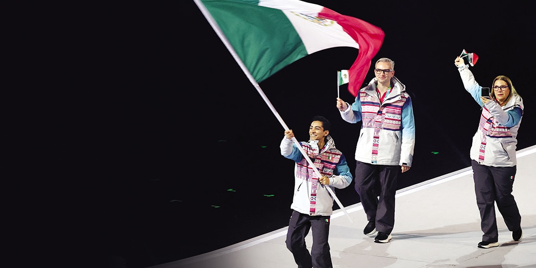 Donovan Carrillo y la delegación nacional con la bandera de México.