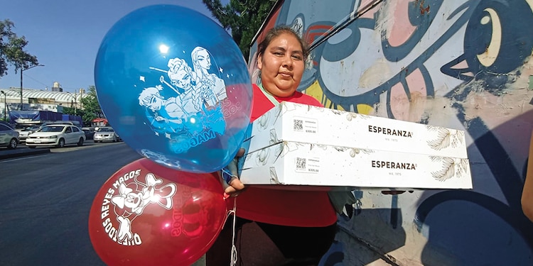 Una mujer posa en Sur 16 con dos roscas, un globo de las Guerreras del K-Pop y otro de Minnie.