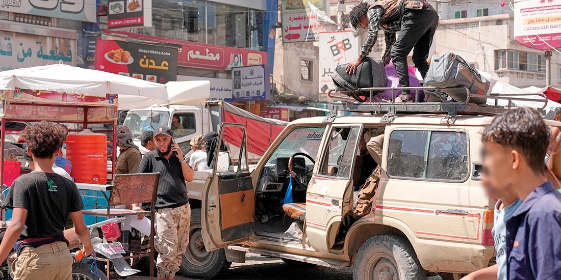 Personas desplazadas, en una estación de minibuses para abandonar Taiz, Yemen, ayer.
