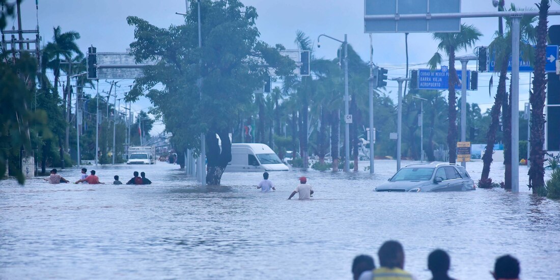 Habitantes caminan entre las calles inundadas, buscando alimentos o en busca desalojar la zona.