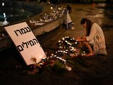 Una mujer enciende una vela en honor a las víctimas del ataque de Hamas durante una vigilia en Dizengoff en el centro de Tel Aviv el viernes 13 de octubre del 2023