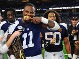 Micah Parsons comiendo una pierna de pavo tras recibir el trofeo de John Madden en el Día de Acción de Gracias