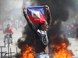 Una persona sostiene una bandera de Haití durante una protesta