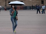 Debido a las altas temperaturas, capitalinos se cubren de los rayos del sol en las calles del Centro Histórico