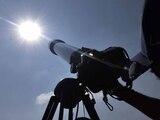 Estudiantes observan el sol con telescopios.